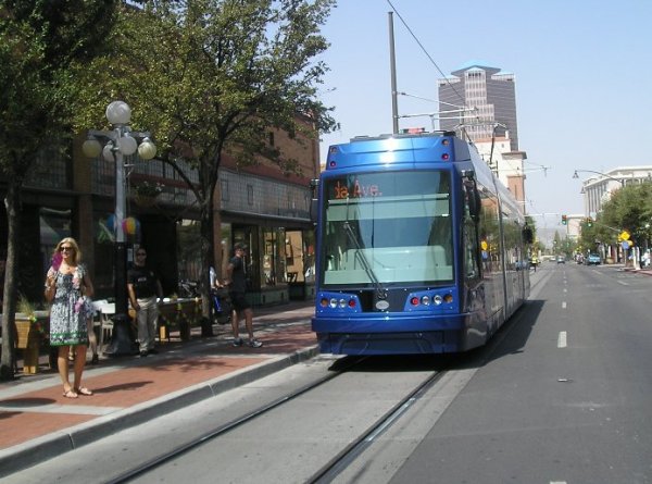 Tucson's new Sun Link streetcar passes sidewalk cafe during opening day festivities. Photo: Ed Havens.